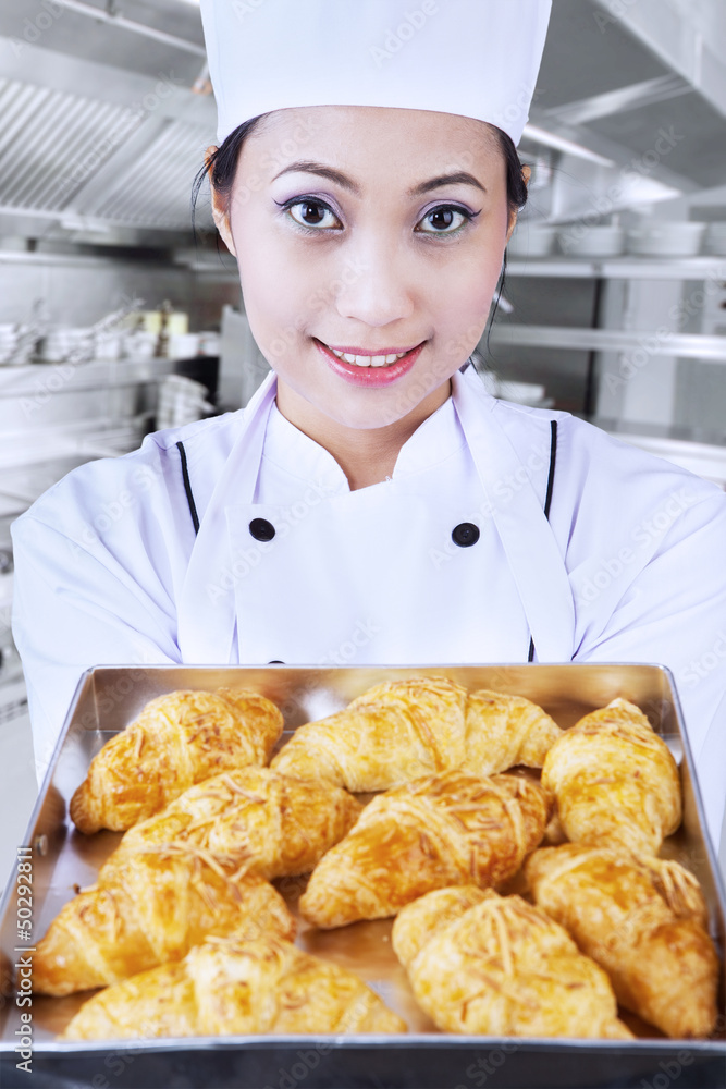 Baker brings croissant in kitchen Baker brings croissant in kitchen