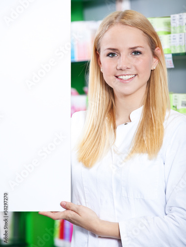 Verkäuferin steht neben weißer Tafel photo