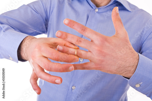 Canvas Print Young man taking off his golden wedding ring.