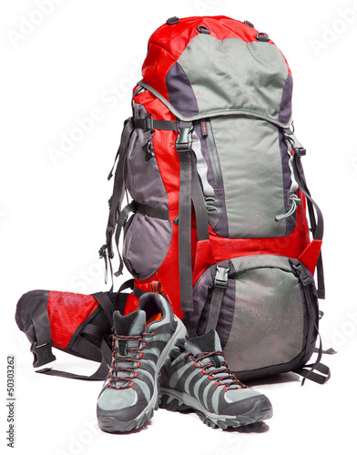 Hiking shoes and packed backpack on white background