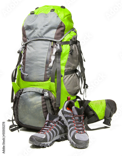 Hiking shoes and packed backpack on white background