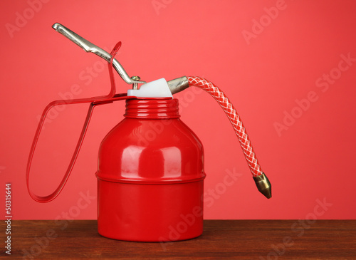 Oil can on red background