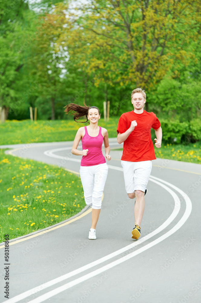 Young man and woman jogging outdoors