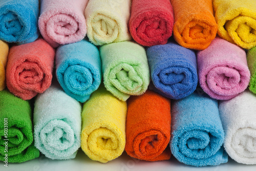 Set of colored towels on white.