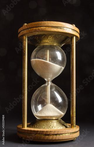 Old hourglass on black background