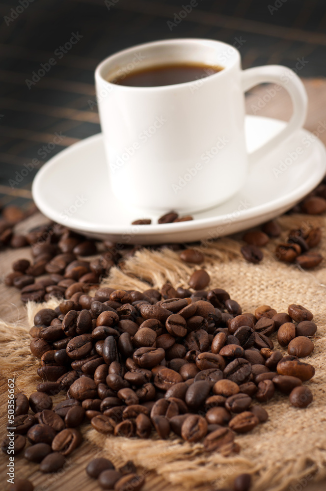 closeup view of a cup of coffee and coffee beans closeup view of a cup of coffee and coffee beans