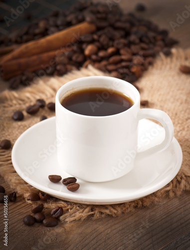 closeup view of a cup of coffee and coffee beans © timolina
