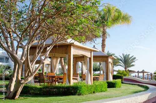 Luxury beach gazebo with white canopy in garden © Masyanya