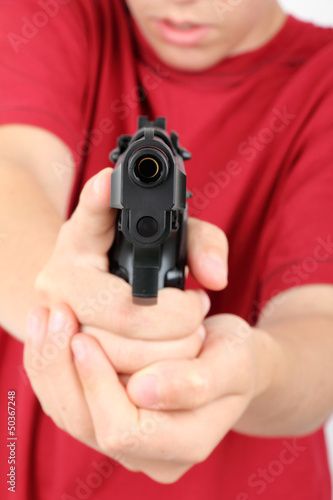 teens hand with gun, short focus on the gun