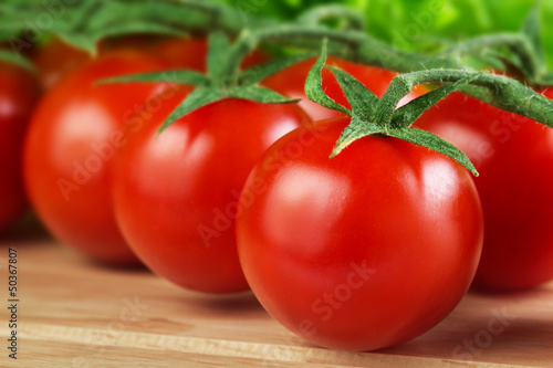 fresh  cherry tomatoes closeup on the chopping board © tananddda