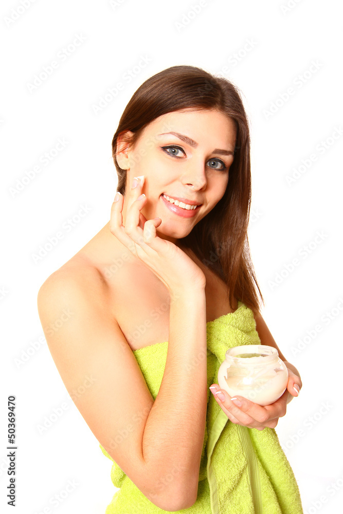Portrait of young woman with cream and a towel on a white backgr Portrait of young woman with cream and a towel on a white backgr