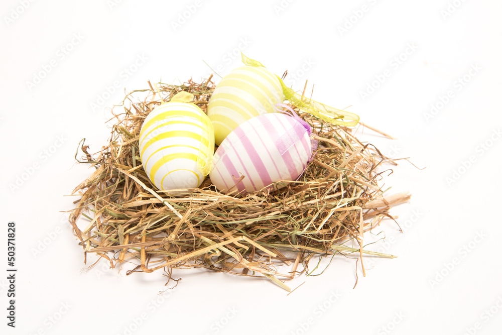 Obraz premium Three easter eggs in straw