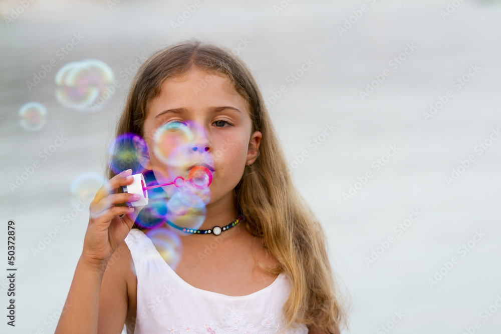 Summer joy - lovely girl blowing soap bubbles Summer joy - lovely girl blowing soap bubbles