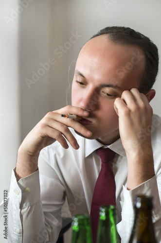 Geschäftsmann raucht gelangweilt in einer Bar