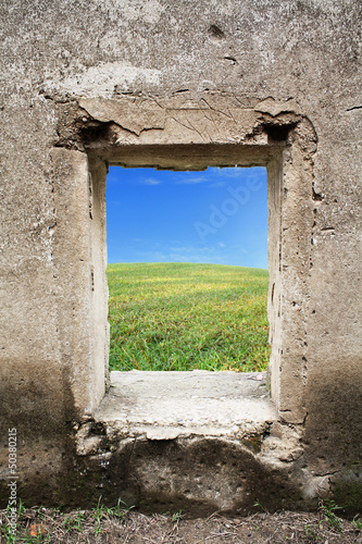 green grass and blue sky behind old castle window