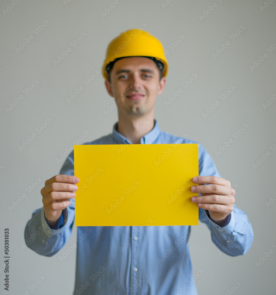 A man in a helmet holding sheets of paper A man in a helmet holding sheets of paper