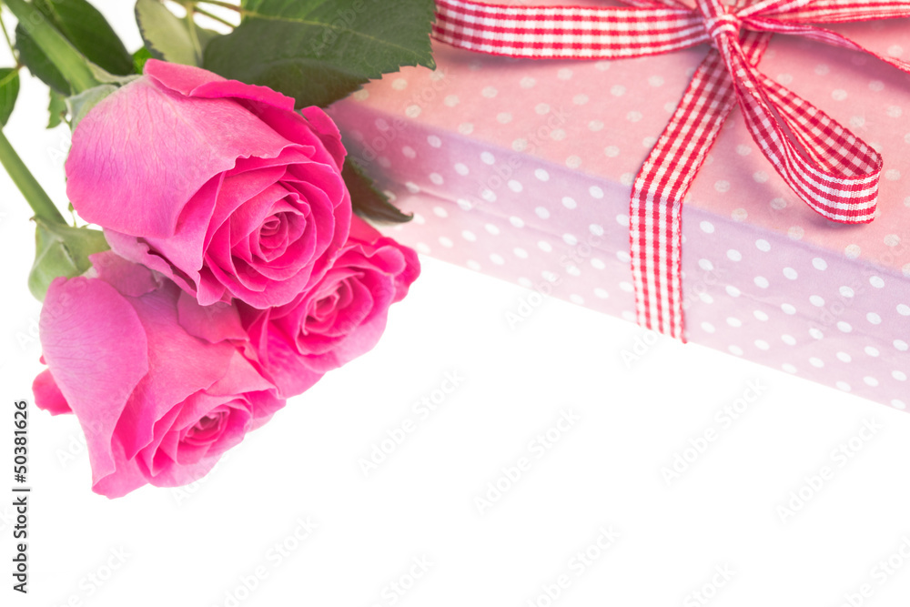 Pink roses resting on pink polka dot wrapped present with copy s Pink roses resting on pink polka dot wrapped present with copy s