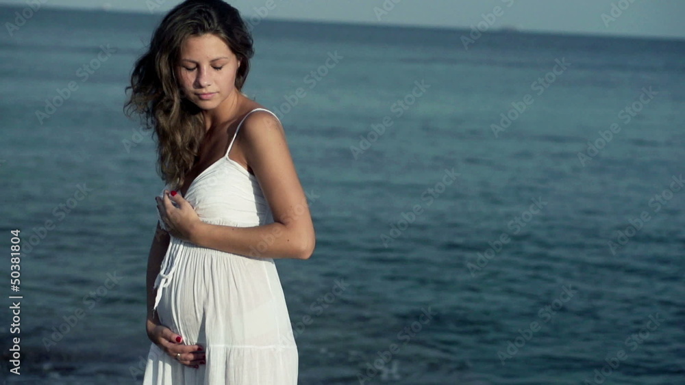 Pregnant woman standing on the seashore, slow motion shot at 240 Pregnant woman standing on the seashore, slow motion shot at 240