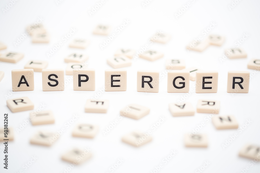 Asperger spelled out in plastic letter pieces with others scatte Asperger spelled out in plastic letter pieces with others scatte