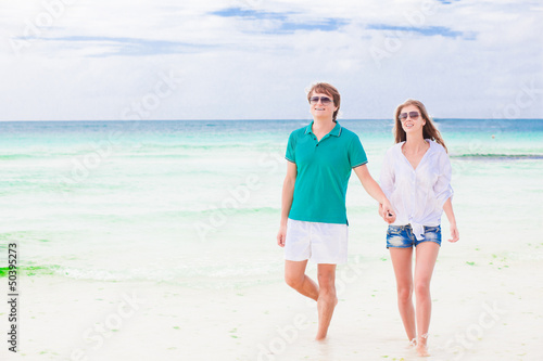 happy young couple walking on the beach