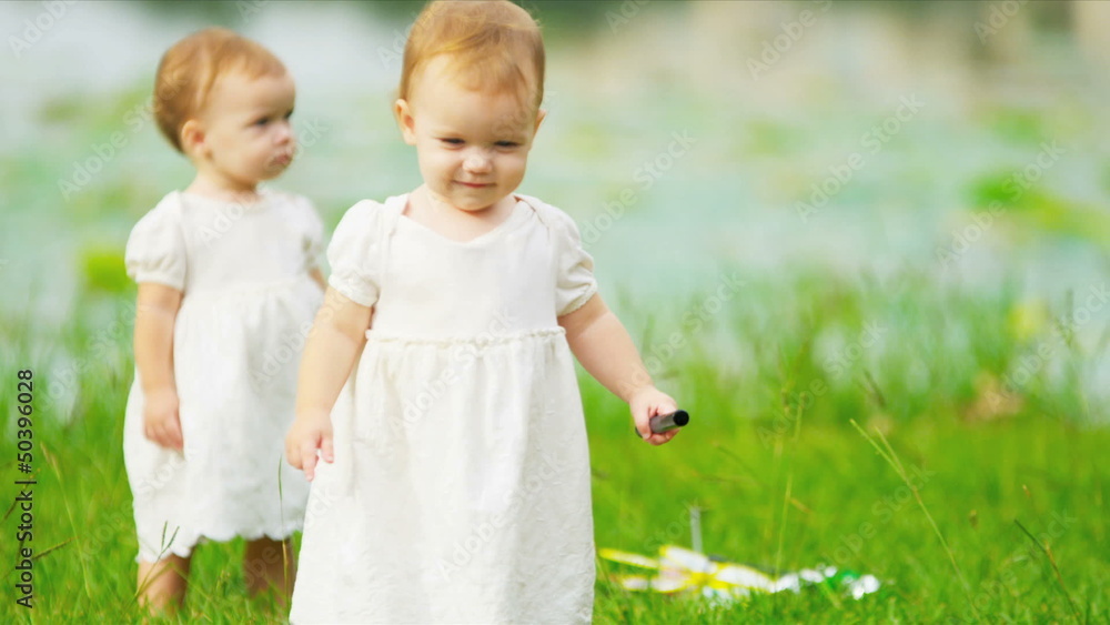 Happy Caucasian children toddling together in park Happy Caucasian children toddling together in park