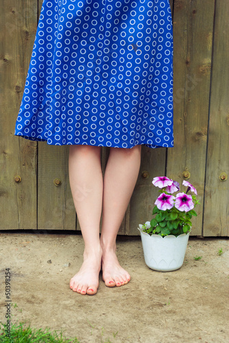 Female legs and a pot of flowers.