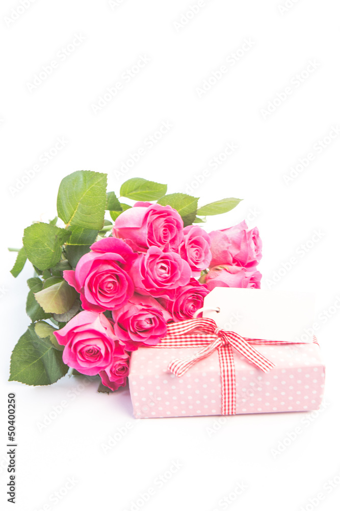 Bouquet of roses next to a gift with a blank card Bouquet of roses next to a gift with a blank card
