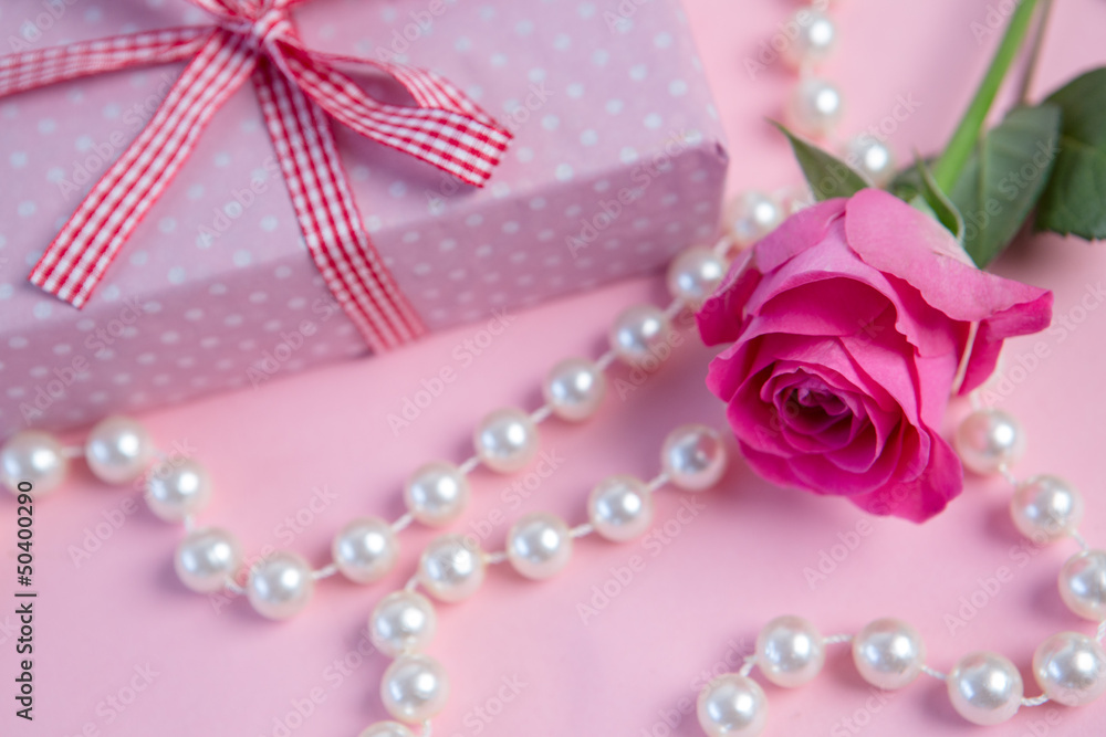 Pink rose with gift and string of pearls Pink rose with gift and string of pearls