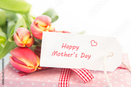 Fototapeta Naklejka Na Ścianę i Meble -  Bouquet of tulips next to a gift with a happy mothers day card