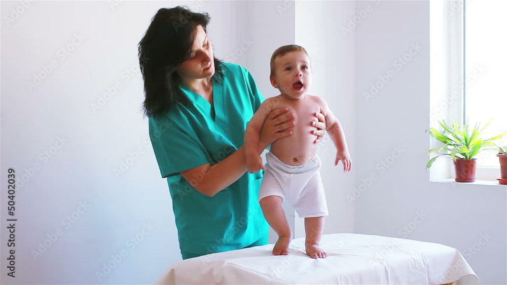 Nurse playing with a baby in hospital, helping to step