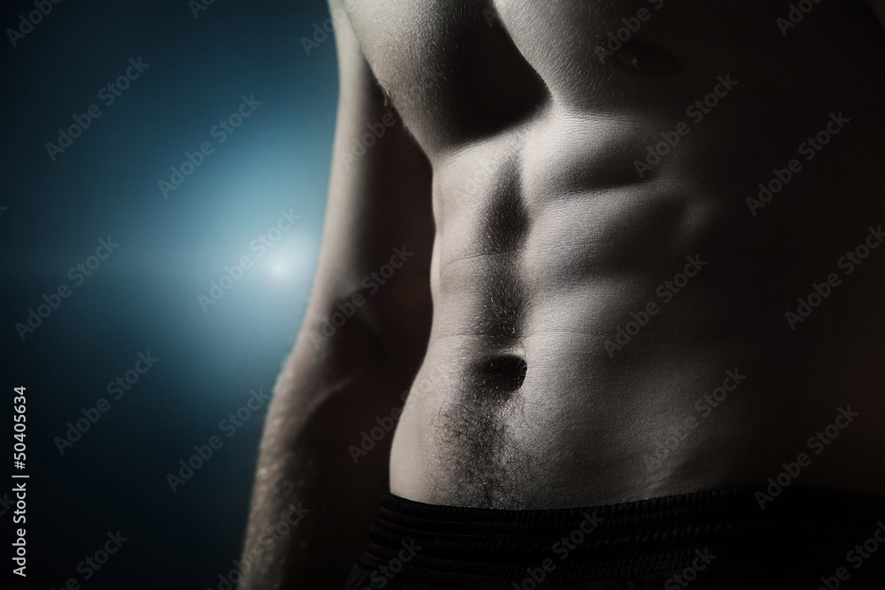 Naklejka premium Muscular naked man on dark background