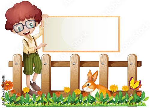 A boy at the fence holding an empty board