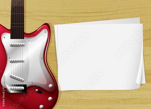 A red guitar with an empty piece of paper