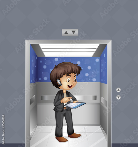 A boy holding an ipad inside the elevator