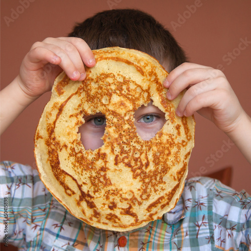 Boy is eating pancake photo