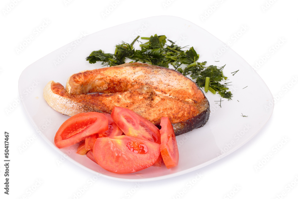 Salmon steak with vegetables on plate. Isolated on white Salmon steak with vegetables on plate. Isolated on white