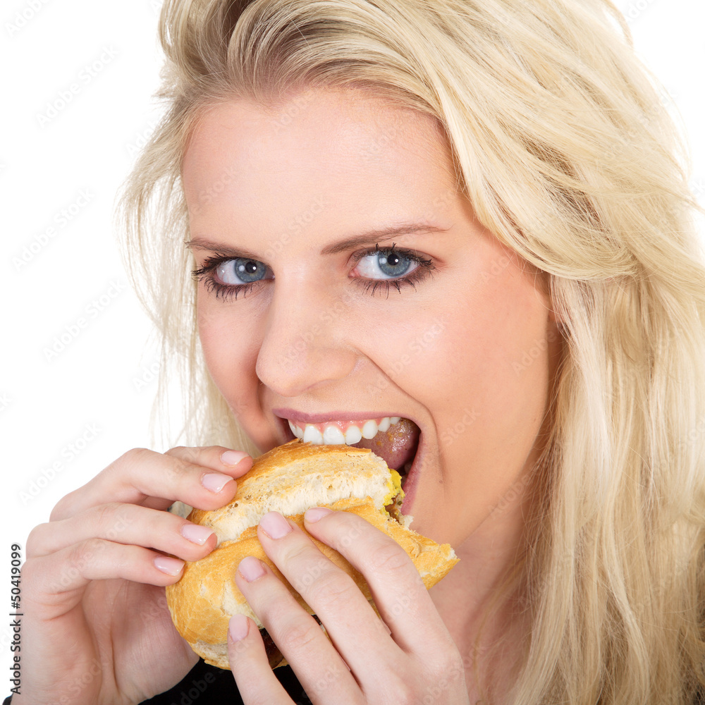 Hübsche blonde Frau isst Bratwurstbrötchen Nahaufnahme Hübsche blonde Frau isst Bratwurstbrötchen Nahaufnahme
