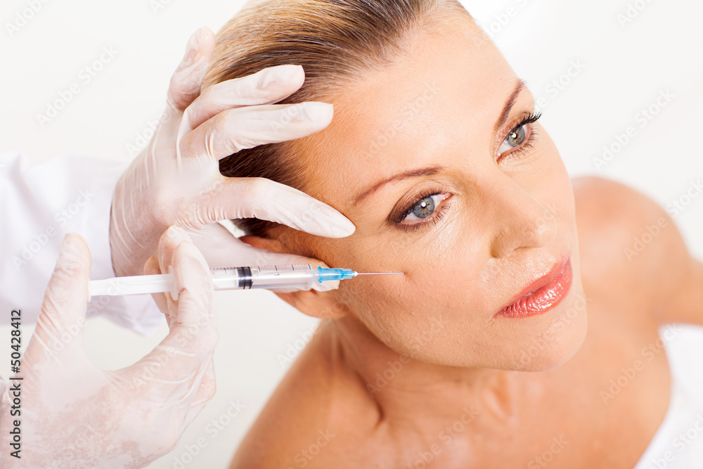 doctor giving mid age woman face lifting injection