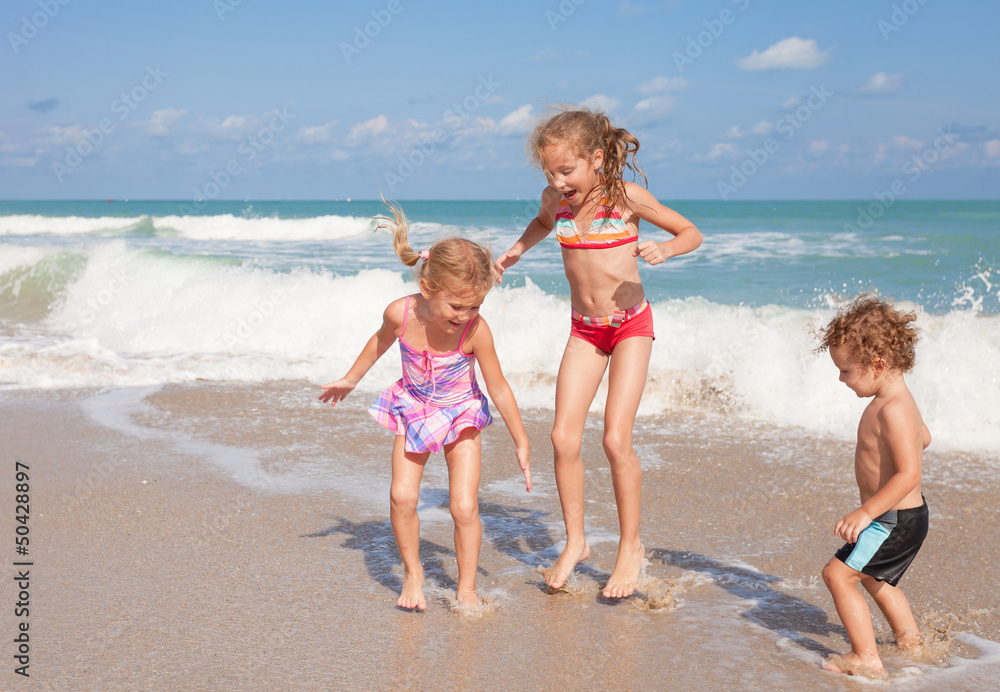 Naklejka premium happy kids playing on beach