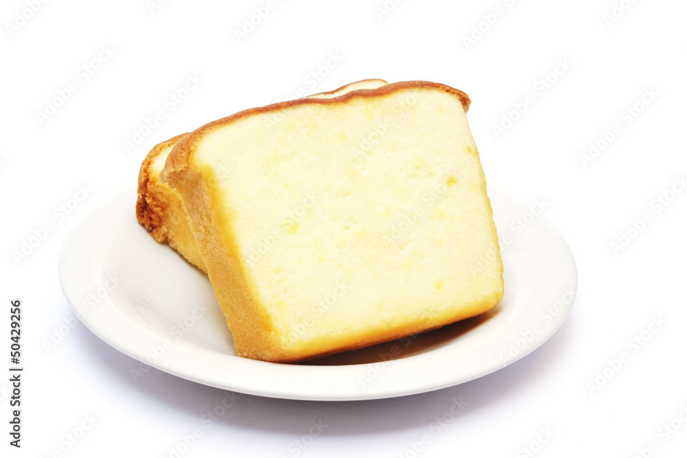 Sliced butter cake on plate with white background