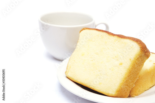 Sliced butter cake and cup of coffee on white background