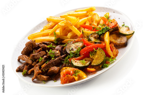 Grilled meat with French fries and vegetables