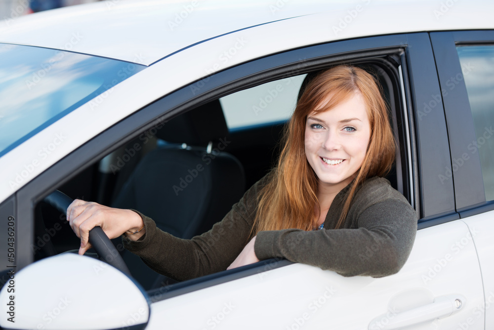 lächelnde junge frau in ihrem auto StockFoto Adobe Stock