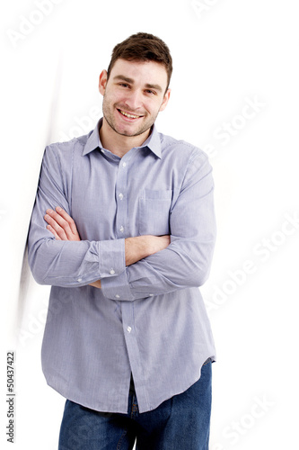 Handsome man leaning against a white wall