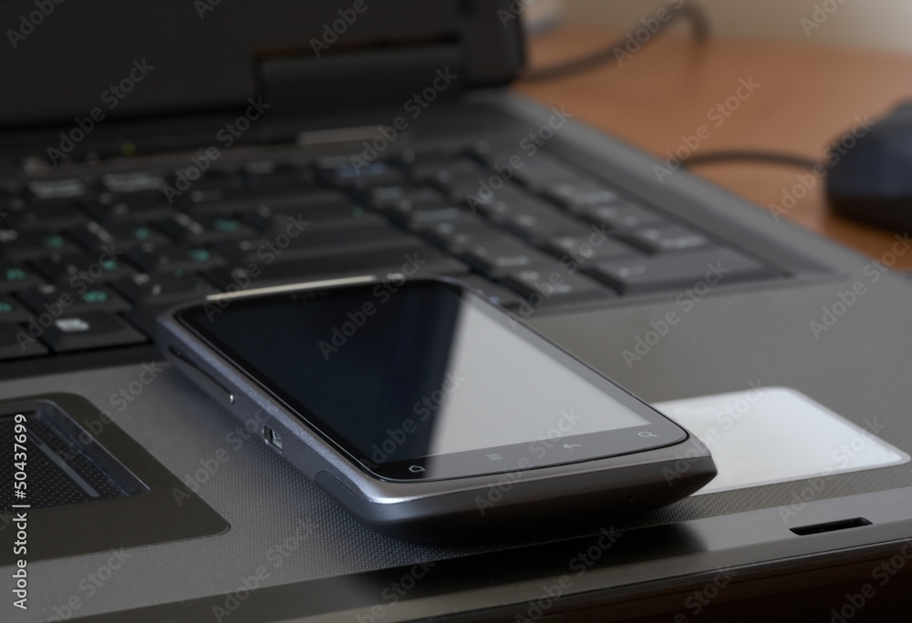 a mobile phone over laptop keyboard a mobile phone over laptop keyboard