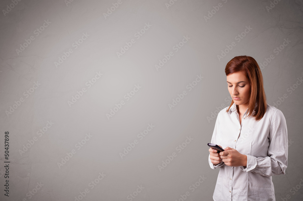 young lady standing and holding a phone with copy space young lady standing and holding a phone with copy space