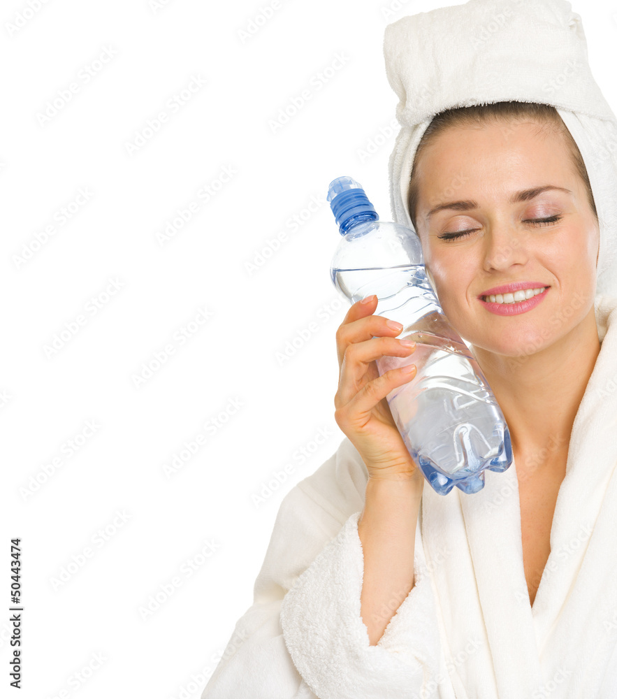 Young woman in bathrobe holding bottle with water Young woman in bathrobe holding bottle with water