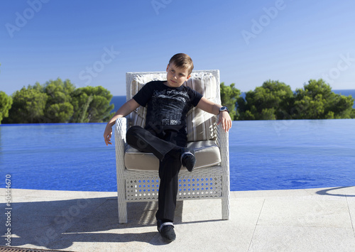 young man in slacks and a shirt sitting in a chair