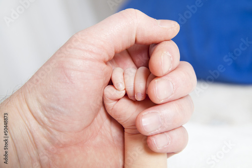 holding a hand of the newborn child
