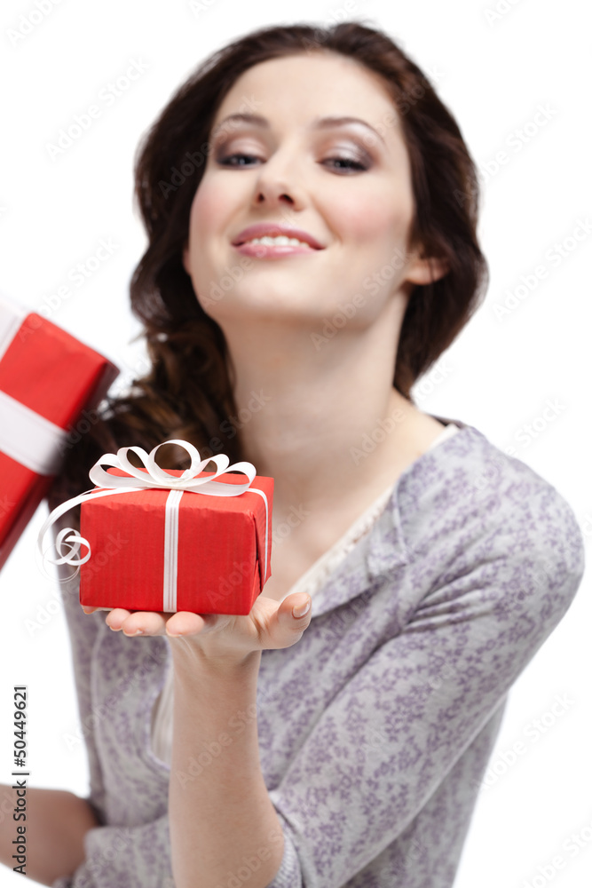 Young woman demonstrates a gift wrapped in red paper Young woman demonstrates a gift wrapped in red paper